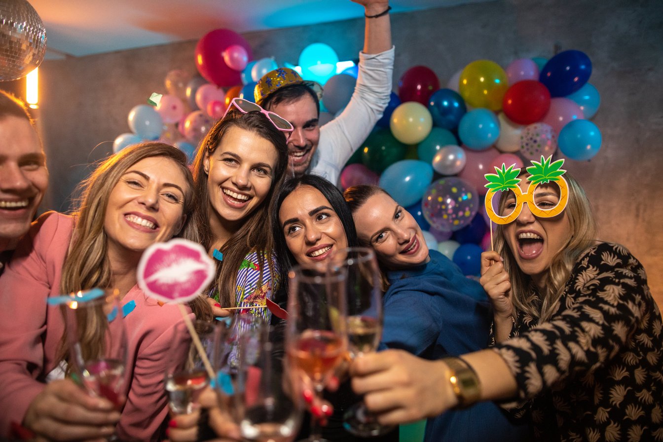 Friends using photo booth props at a New Year's party